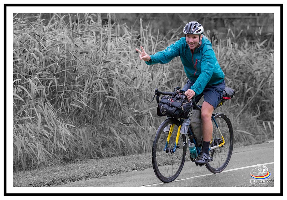 Jimmy Ashby rides his bicycle past a field during his trip around the world to raise money for MND