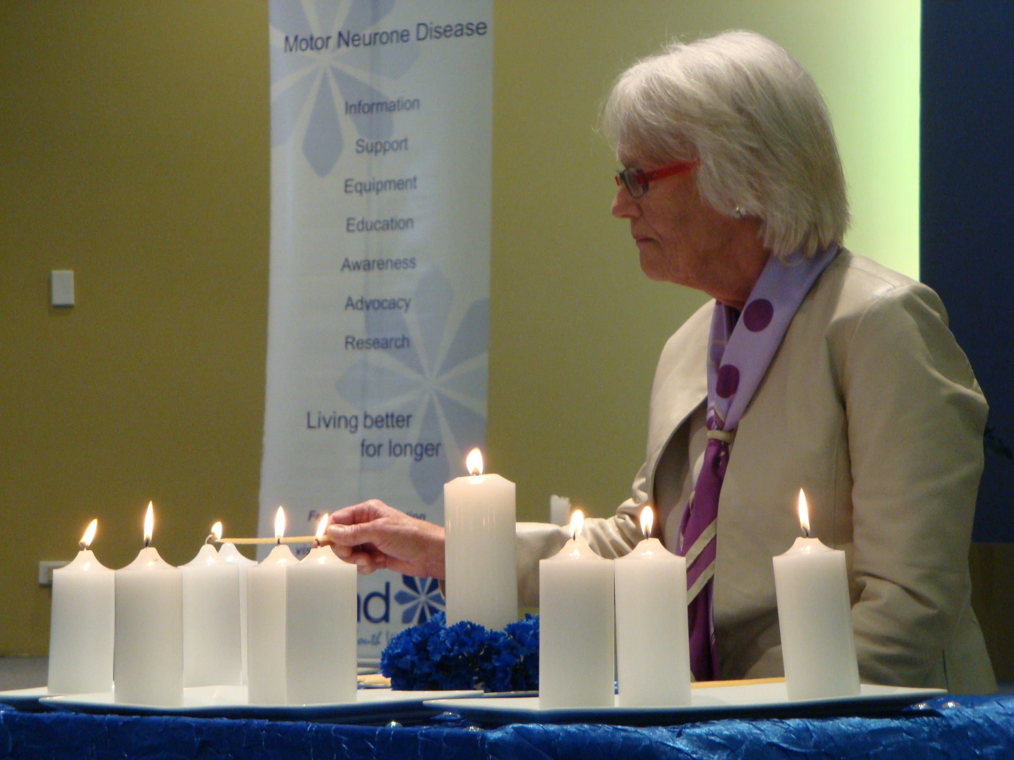 Janet Nash lighting candles in remembrance of people who died from MND